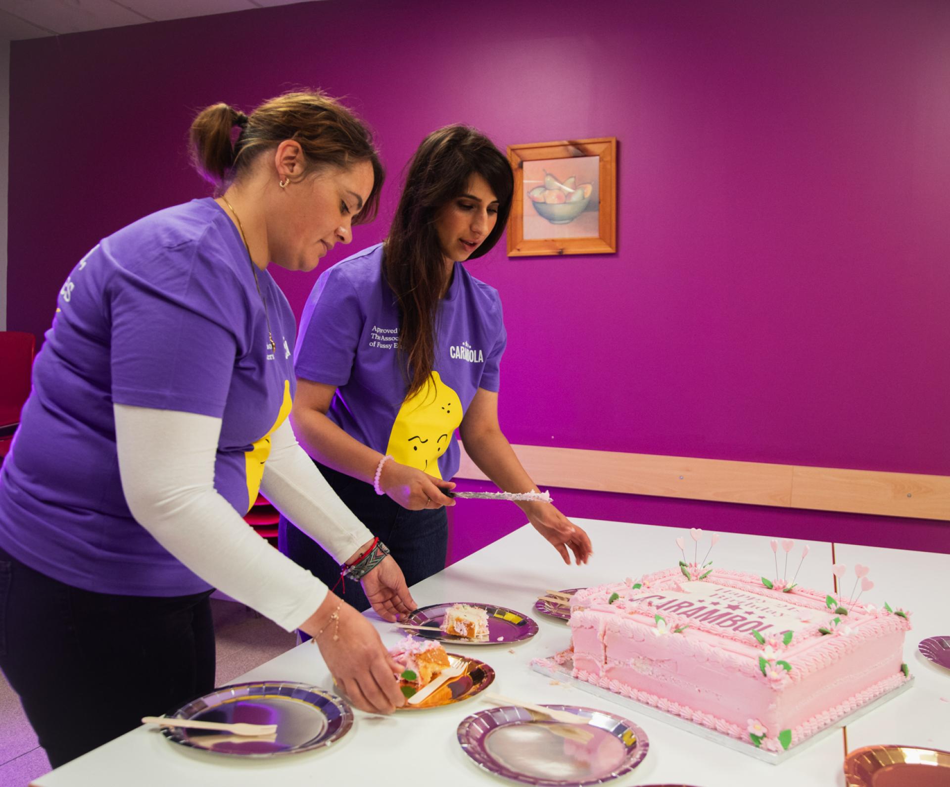 Carambola team members cutting cake